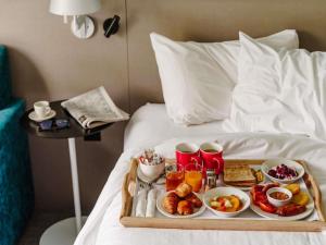 a tray of breakfast food on a bed at Mercure Haydock Hotel in Haydock