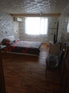 a bedroom with a bed and a window and a chair at Апартамент in Razgrad