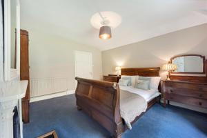 a bedroom with a wooden bed and a dresser at The West Wing in Whitford