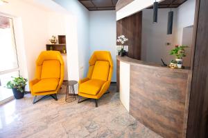 two yellow chairs in a waiting room with a counter at Vila Aura in Sovata +12 photos