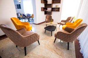 a waiting room with yellow chairs and tables at Vila Aura in Sovata