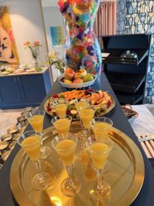 a tray with wine glasses and a plate of food at Kullagård Hotell in Mölle