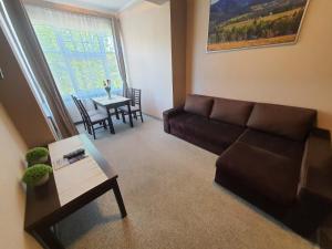 a living room with a couch and a table at Apartamenty Kostka in Karpacz