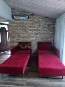 two red beds in a room with a brick wall at Namiņš AMRAI in Ventspils