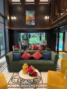 a living room with a green couch and a table at A Cozy Condo Near Central-BJ in Ban Rangeng