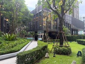 a building with a tree in the middle of a park at A Cozy Condo Near Central-BJ in Ban Rangeng