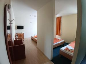 a hotel room with two beds and a mirror at City Hotel Siófok in Siófok