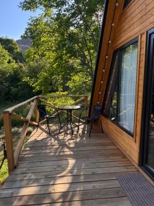 a wooden deck with a table and chairs on it at Chachkari Cottage in Gogasheni