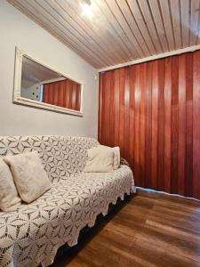 a living room with a couch and a wooden wall at Namiņš AMRAI in Ventspils