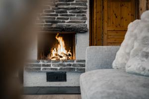 a fireplace in a living room with a couch at Chalet Ruka Aurelius in Ruka