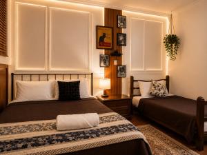 a bedroom with two beds and a table with a lamp at Nagomi Casa amplia para empresas, grupos y familias in Pachuca de Soto
