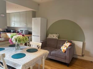 a living room with a couch and a table at Central Derby pride park 4 bedrooms 7 beds -Spacious contractors large group -Cul de Sac EasyFREE PARKING in Derby