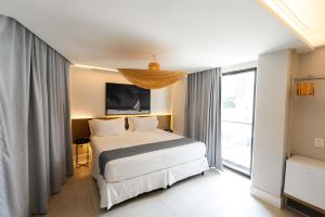 a bedroom with a bed and a large window at Tintto Hotel in Fortaleza +72 photos