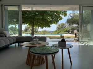 a living room with two tables and a large window at Maison orchidée in Nîmes