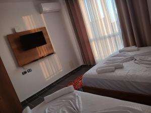 a hotel room with two beds and a flat screen tv at Enes apartament in Krujë +7 photos
