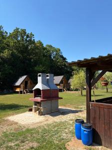 a brick oven in a field with a house in the background at Green River - robinzonski kamp in Duga Resa +95 photos
