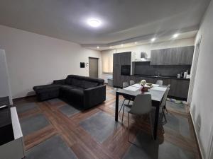 salon z czarną kanapą i stołem w obiekcie Ballaretthouse B&B w mieście Luzzi