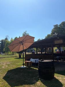 an umbrella and a table in a park at Green River - robinzonski kamp in Duga Resa