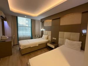 a hotel room with two beds and a window at Ayseli Hotel in Mersin +39 photos