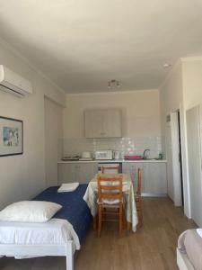 a bedroom with a bed and a table and a kitchen at Paraschos Studios Kos in Kardamaina +56 photos
