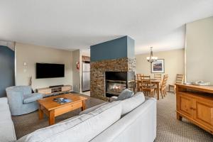 a living room with a couch and a fireplace at The Snowbird by Whiski Jack in Whistler +71 photos