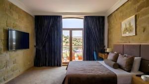 a bedroom with a bed and a large window at Senator panoramic Hotel in Baku