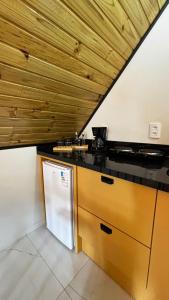 a kitchen with a black counter top and wooden ceilings at Sombra do baú - Aurora in Timbe do Sul