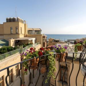 a balcony with flowers on the balconies of a building at Senator panoramic Hotel in Baku
