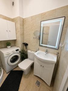a bathroom with a toilet sink and a washing machine at ROYAL MIRAGE Militari Residence in Chiajna +13 photos