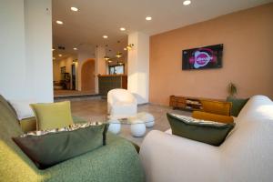 a living room with two couches and a tv at AViSOS HOTEL & APARTMENTS in Marmaris