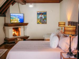a bedroom with a white bed and a fireplace at Lê Château Hotel de Gramado, seu refúgio no centro da cidade in Gramado +40 photos
