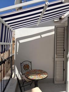 a patio with a table and a chair on a balcony at Vic e Vicariell in Gaeta