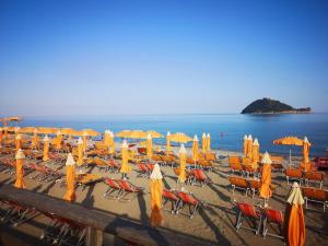 a bunch of chairs and umbrellas on a beach at Hotel Stazione del Sole in Albenga