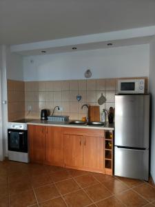 a kitchen with a stainless steel refrigerator and a stove at Studio dwupokojowe z łazienką i kuchnią in Augustów