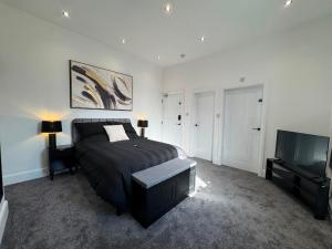 a bedroom with a bed and a flat screen tv at The Carlton Collection in Birkenhead