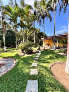 a walkway in front of a house with palm trees at Villa Dona Jaca - Casa da Mata - 01 in Socorro