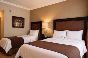a hotel room with two beds and a lamp at The Inn at UCLA in Los Angeles