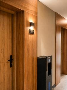 a black refrigerator in a room with a wooden wall at Hotel Evo in Witunia
