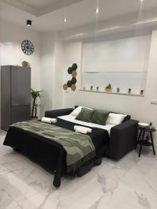 a bedroom with a large bed and a black couch at Karma apartment in Catania