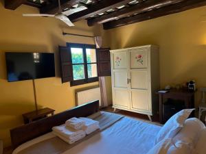 a bedroom with a bed and a tv and a bed sidx sidx sidx at Hostal La Riera de Peratallada in Peratallada