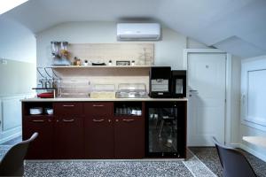 a kitchen with brown cabinets and a microwave at Hotel Caffaro in Genoa