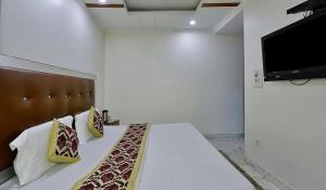 a bedroom with a bed with pillows and a flat screen tv at Family Group with Provide By PG Hotel Near New Delhi Railway station & Karol-Bagh in New Delhi +41 photos