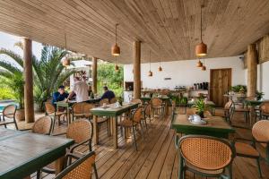 a restaurant with tables and chairs on a wooden deck at Suíte Charmosa na Mucugê - Café da manhã opcional - Conforto e Localização Perfeita in Porto Seguro