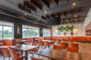 a restaurant with tables and chairs and a flat screen tv at Best Western Plus Kawartha Lakes Hotel & Suites in Lindsay