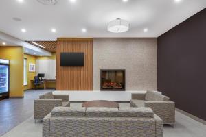 a lobby with couches and a fireplace and a tv at Best Western Plus Kawartha Lakes Hotel & Suites in Lindsay