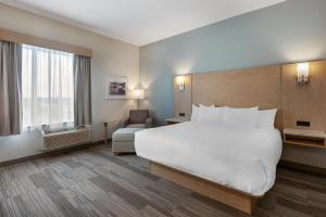 a hotel room with a large bed and a chair at Best Western Plus Kawartha Lakes Hotel & Suites in Lindsay +35 photos