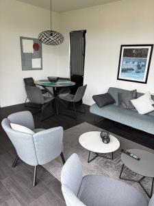 a living room with a couch and chairs and a table at Casa-MiU am Wasser - Olburgen - perfekt für Familien - mit Freibad, Sauna, Restaurant und Spielplatz in Olburgen