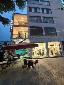 a group of tables and chairs in front of a building at Englishman Hostel Shkoder Backpackers Instant Sleep in Shkodër