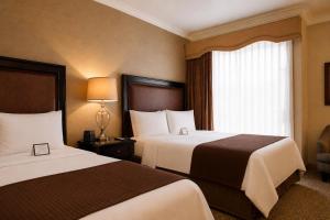 a hotel room with two beds and a window at The Inn at UCLA in Los Angeles +8 photos