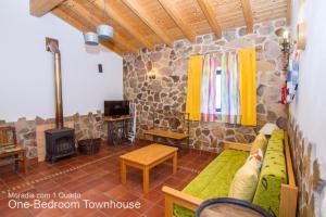 a living room with a couch and a stone fireplace at Akivillas Aljezur Nature in Aljezur